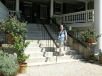 John climbing the steps of the plantation house